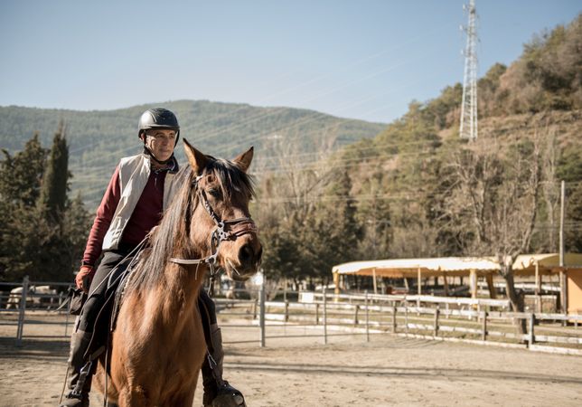 Anonymous people riding horses in brook