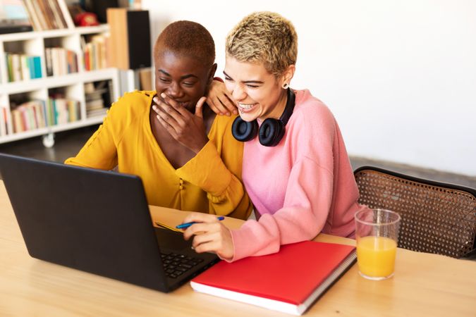 Female friends laughing at laptop