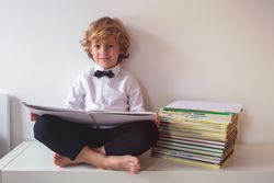Schoolboy in suit reading book