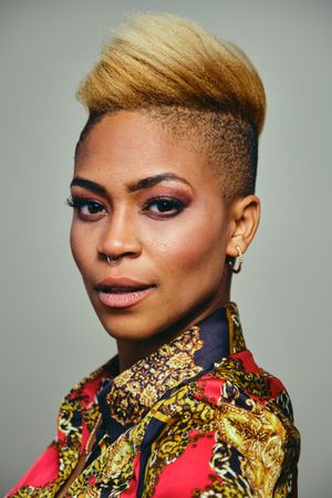 Portrait of confident Black woman posing with short blonde hair in bold patterned shirt