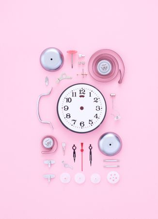 Clock dissembled on pink background