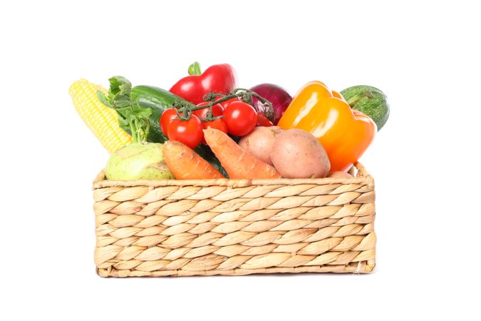 Wicker basket with vegetables isolated on blank background