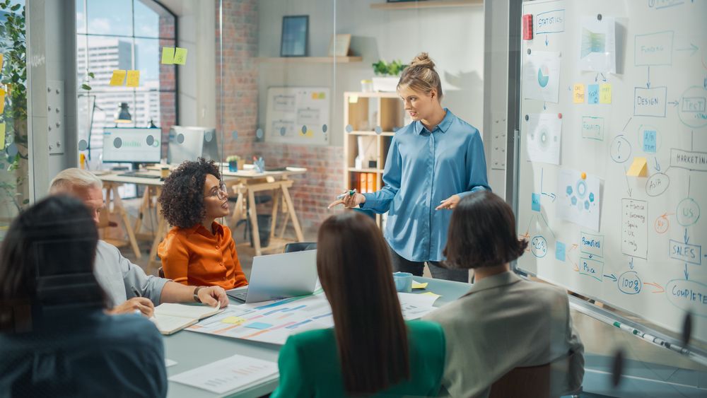 Driven Visionary Businesswoman Leading a Team Meeting in Creative Office Conference Room.