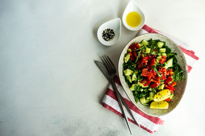 Top view of big grey bowl of healthy tomato salad with copy space