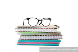 Notebooks topped with glasses in blank space bGVna4