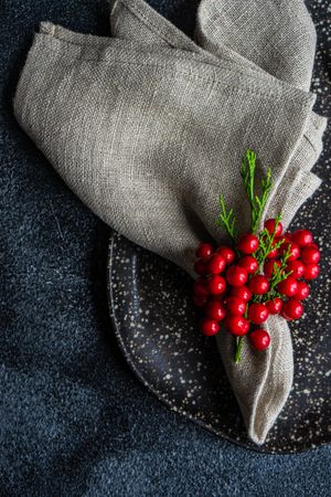 Close up of spotted grey plate and mug surrounded by seasonal red berries