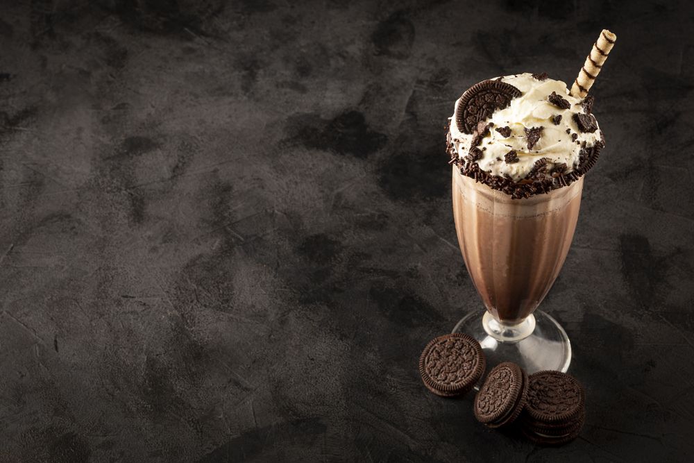 Chocolate milkshake with pieces of chocolate chip cookies.
