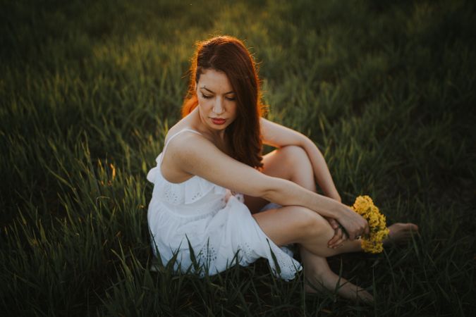 Barefoot woman with flowers in meadow