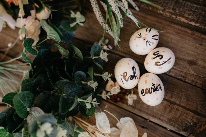 Easter eggs hand painted by children with messages in a wooden table