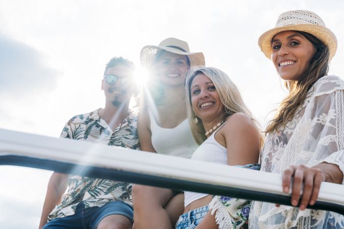 Relaxed friends comfortable placing on top of blue car