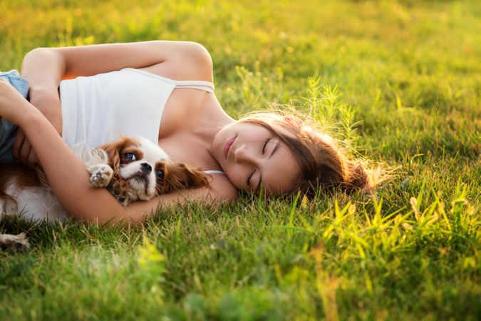 Teen girl happily hugs the dog