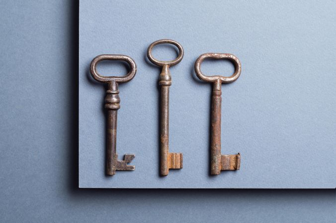 Top view of three vintage keys over gray background
