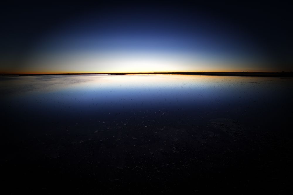 Tranquil blue water surface in dark sunset