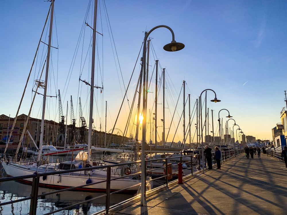 People walking beside docked boats