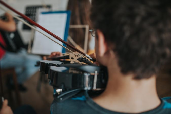 Close up of young boy playing violin at band class