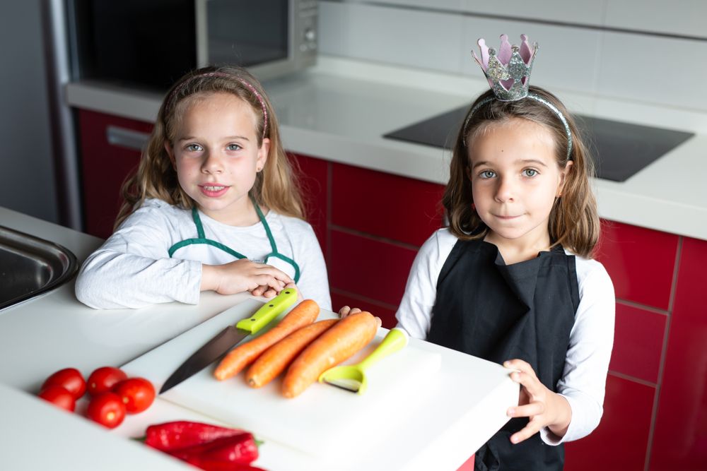 Siblings preparing vegetables for salad