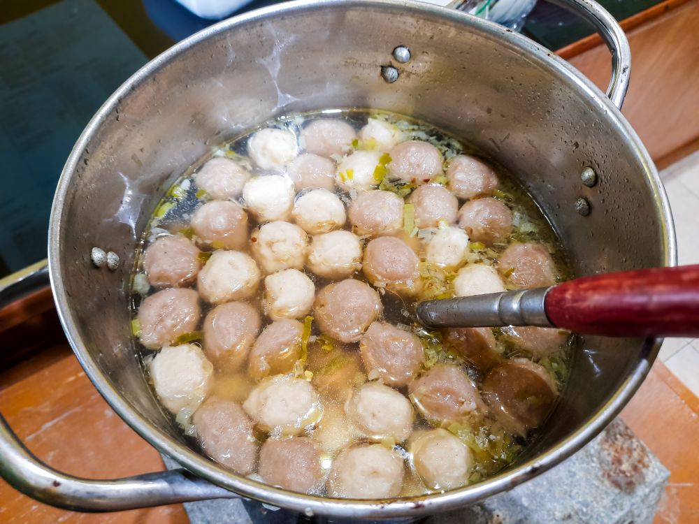 meatballs boiled in a stewpan on the stove, indonesian dish