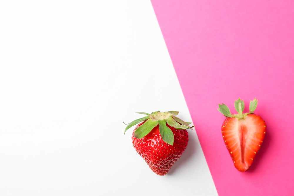 Strawberries on two color background, space for text. Summer sweet fruits and berries