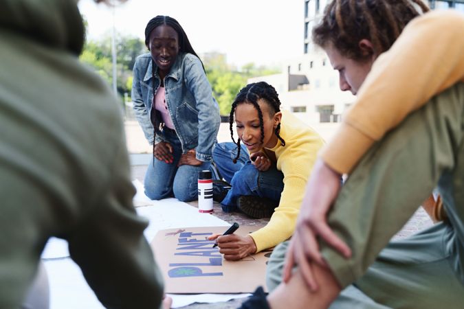Black women creating signs for an environmental protest