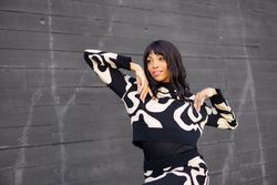 Trendy woman posing outside grey wall