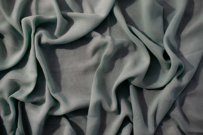 Nude green fabric wavy crumpled background texture with copy space.