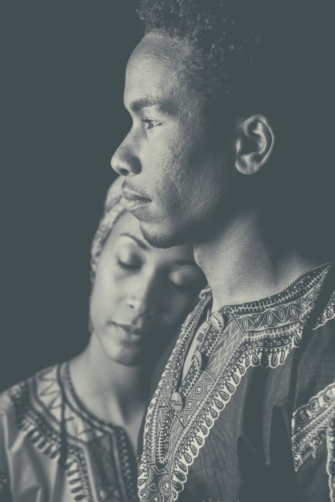 Woman with eyes closed clinging to ethnic man
