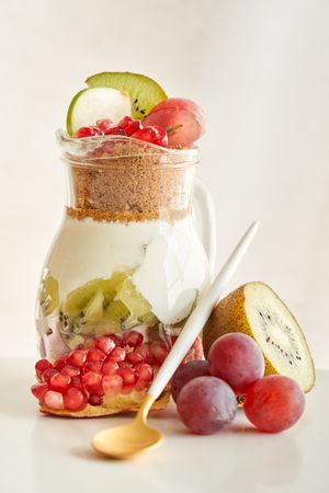 Delicious yogurt dessert with pomegranate, kiwi, grape and ginger biscuit