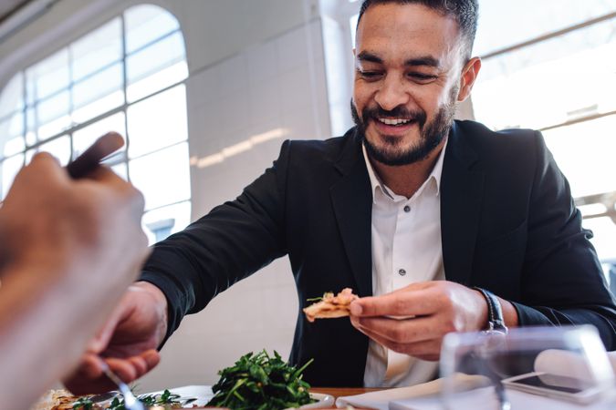 Young businessman having food in restaurant