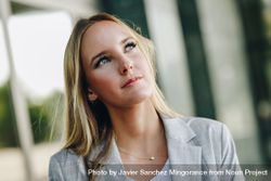 Portrait of woman in blazer looking up 0v38Mg