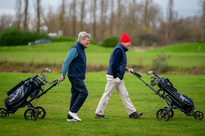 Two men walking on golf course with clubs