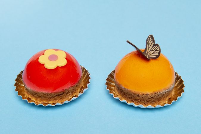 Two delicious looking small round cakes on a blue background with space for copy