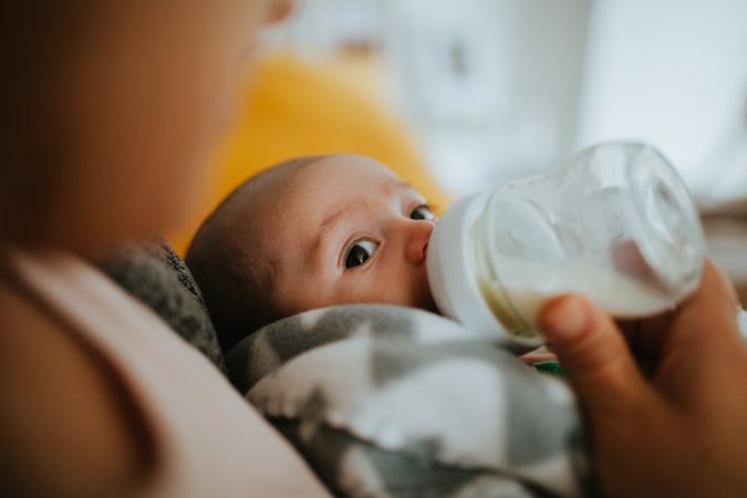 Newborn looks at camera during feeding