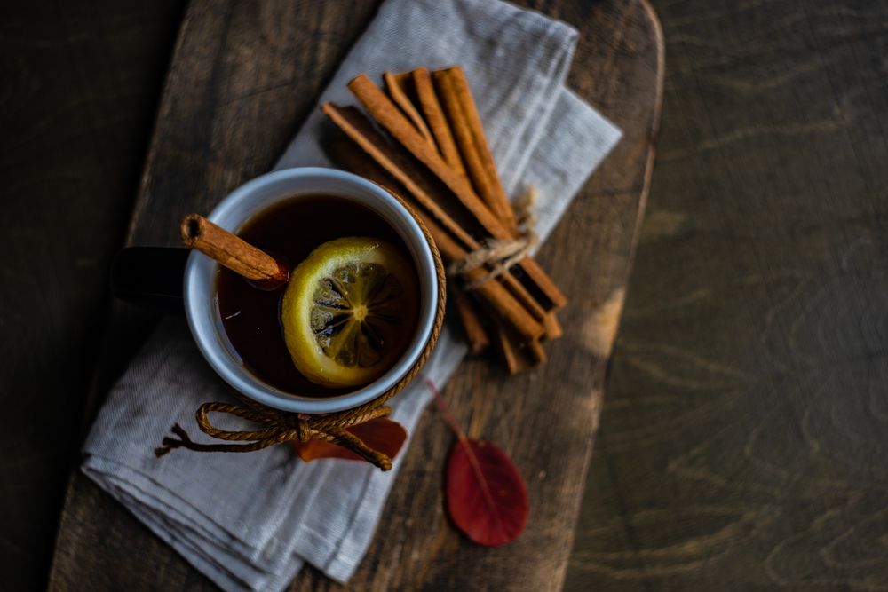 Top view of mug with bunch of cinnamon sticks and lemon slice