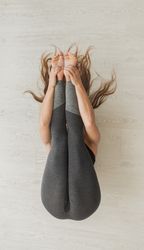 Flexible woman stretching legs to head