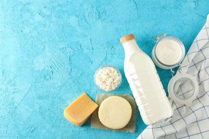 Flat lay composition. Different dairy products on blue background, copy space