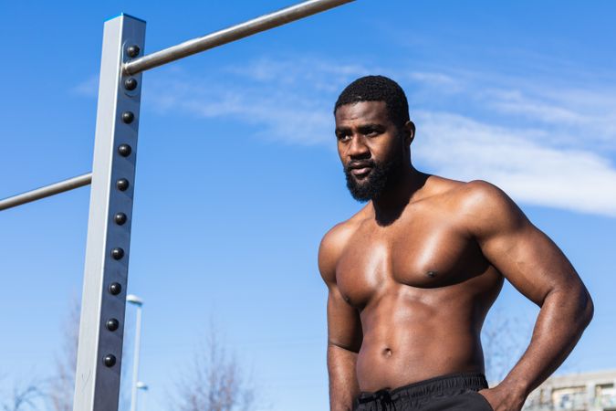 Strong Black sportsman resting during training on sports ground