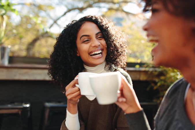 Two women laughing and having fun at a coffee shop
