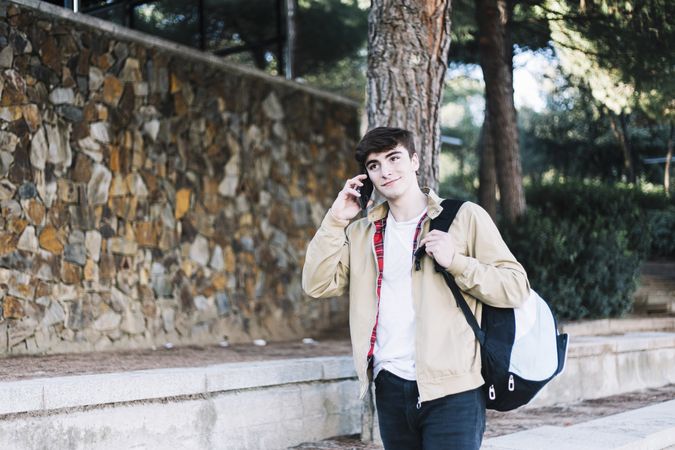 Man strolling outdoors while talking on cell phone