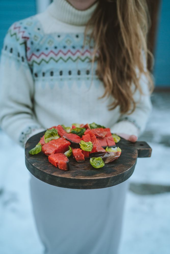 Woman holding a tray of raw meat