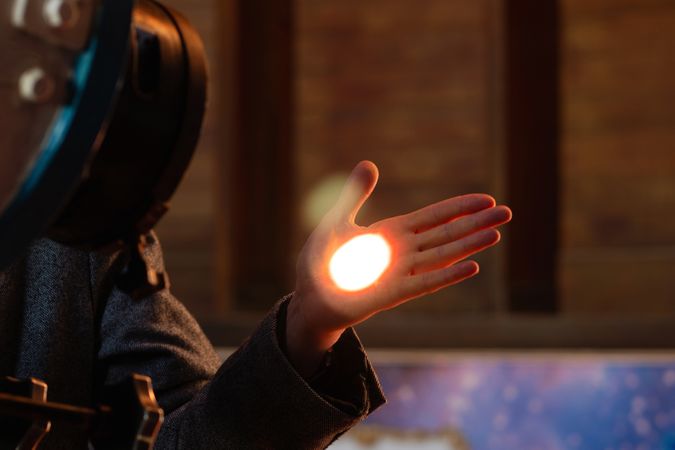 Hand catching the focused light from telescope lens.