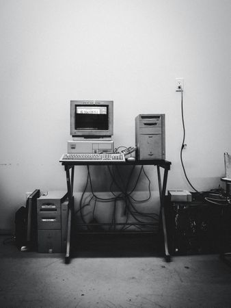 Grayscale photo of computer desktop in a room
