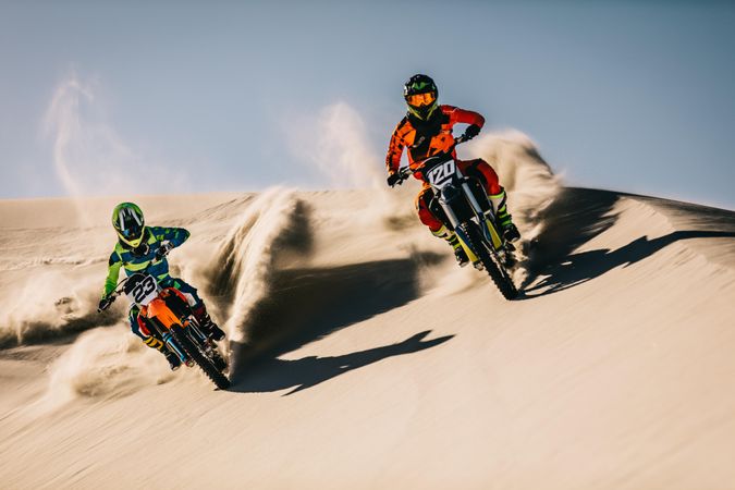 Intense motocross riding over sand dunes