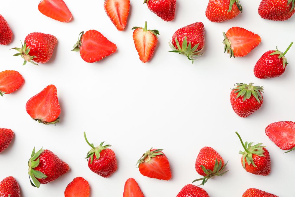 Flat lay composition with strawberries on light background, space for text. Summer sweet fruits and berries