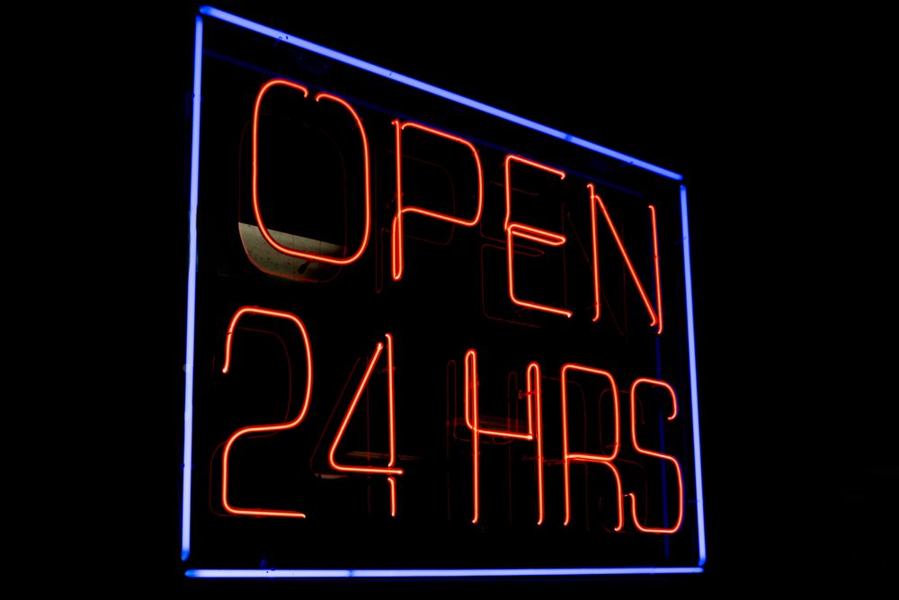 Neon sign open 24 hrs in dark