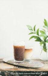 Two cups of ice coffee in glass cups with light background 43x81b