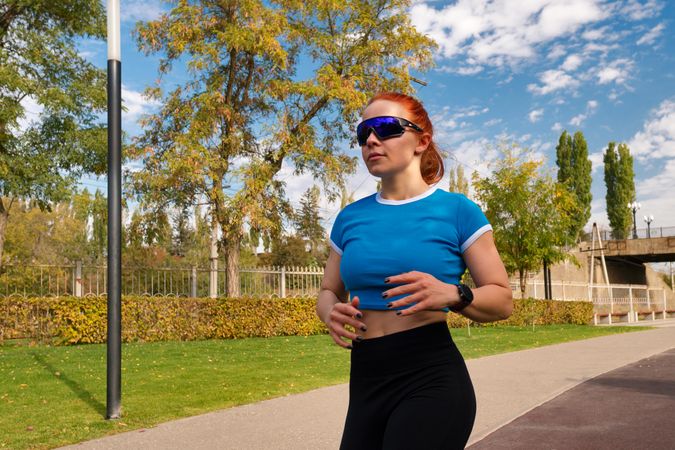 Young woman jogging in park, fitness routine.