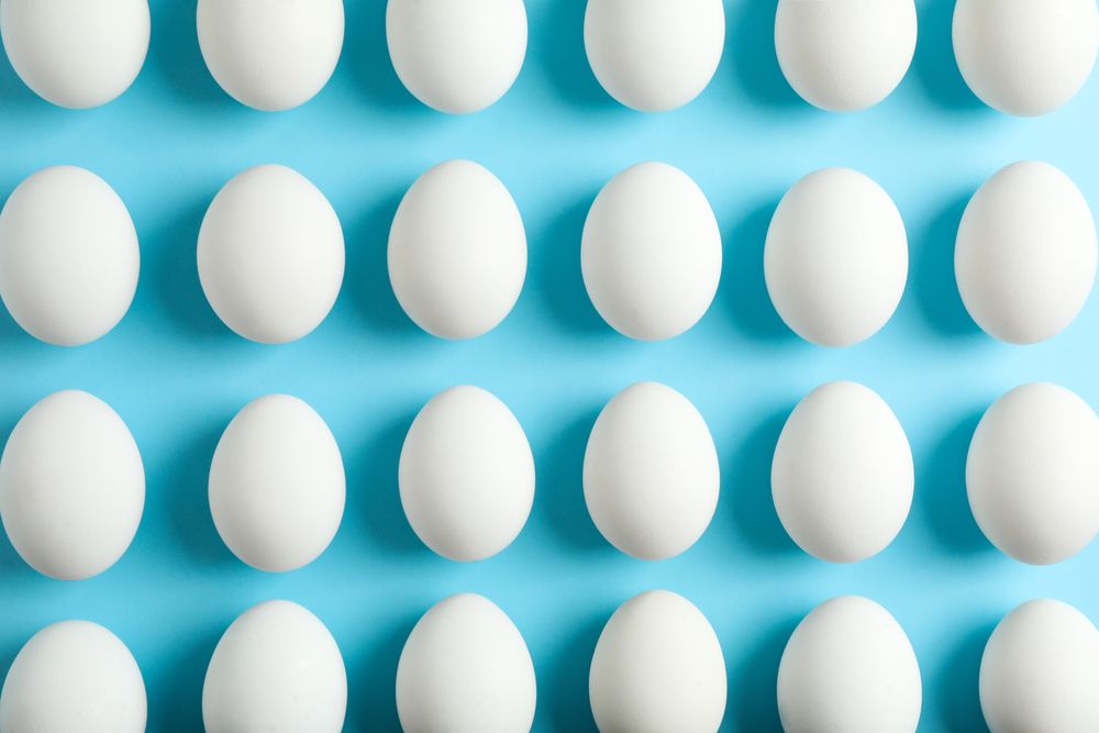 Flat lay composition with chicken eggs on color background, space for text