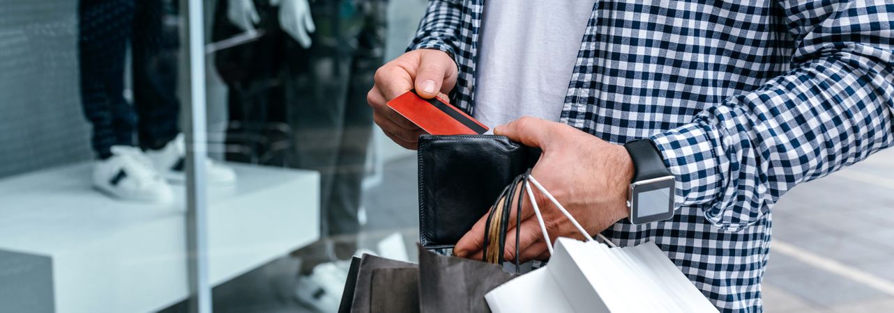 Man taking out credit card to shop