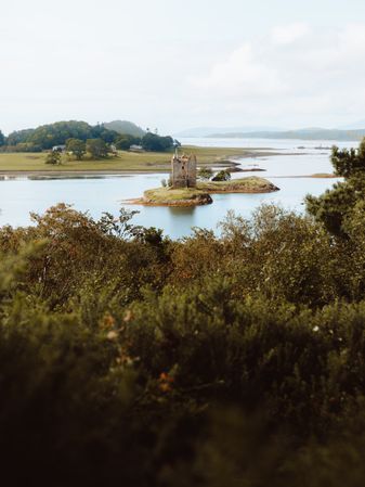 Ancient castle against hills on lake coast