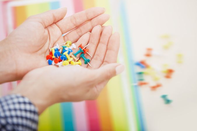 Hands with colorful pushpins